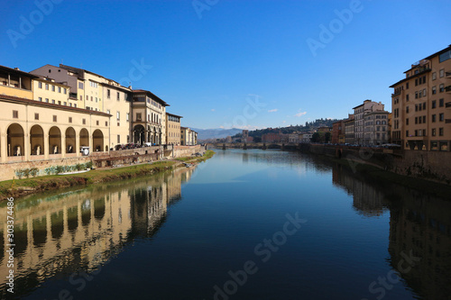 scenic view to Arno river from ponte vecchio in florence italy with bright blue sky