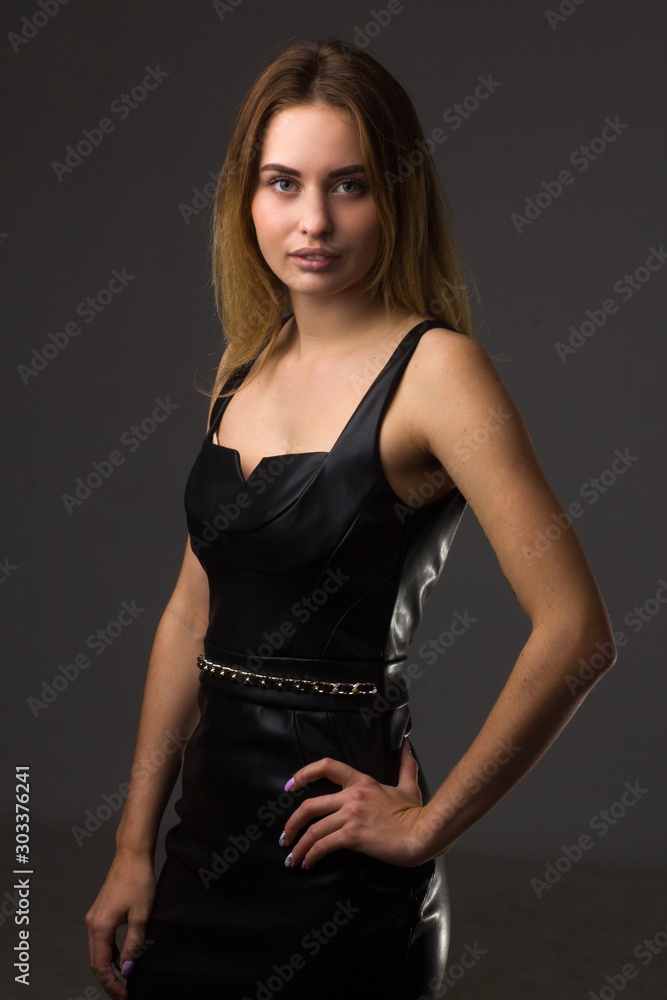 portrait of a young girl in a leather dress on a dark background portrait of a young girl in a leather dress on a dark background
