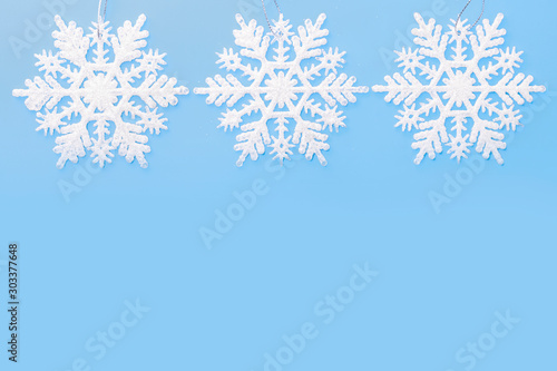 Christmas border of white snowflakes isolated on a blue background. Concept banner border frame background for Christmas and New Year. Copy space © Syrtseva Tatiana