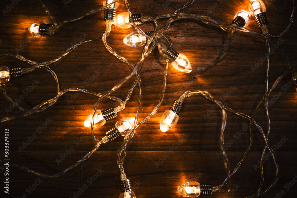 Christmas lights on the wooden background.