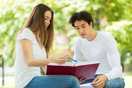Two students studying together sitting on a bench outdoor © Minerva Studio