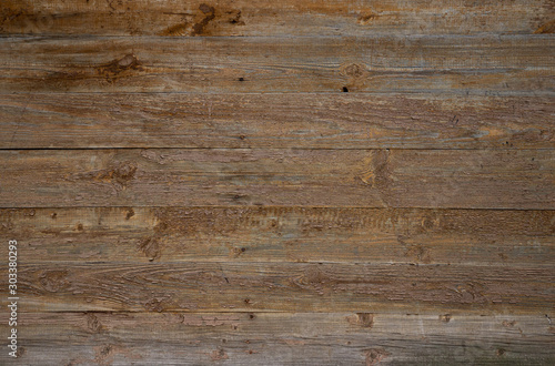 Texture of old wooden wall with peeling beige paint from boards