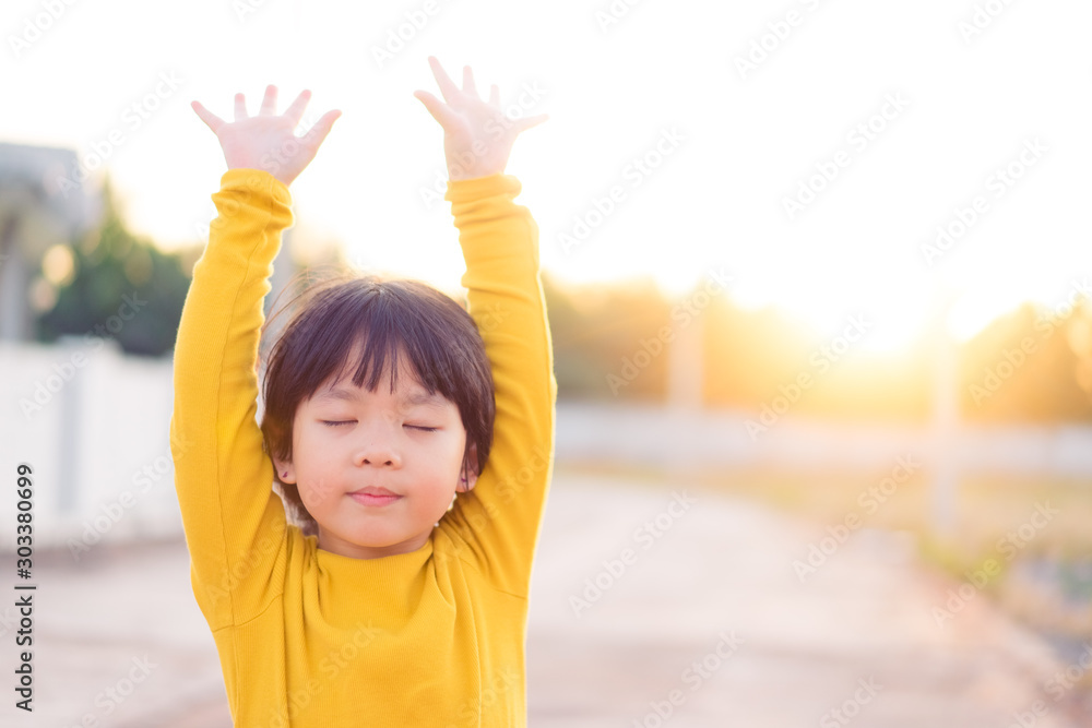 Φωτογραφία Little girl praying and raise hands in the morning for faith, spirituality and religion