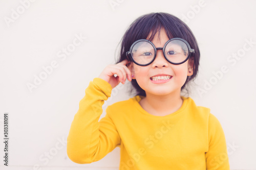 Happy smiling smart and nerd little asian girl in glasses and pointing finger at brain and going to school for the first time.Child with school kindergarten.Child development and Education concept.