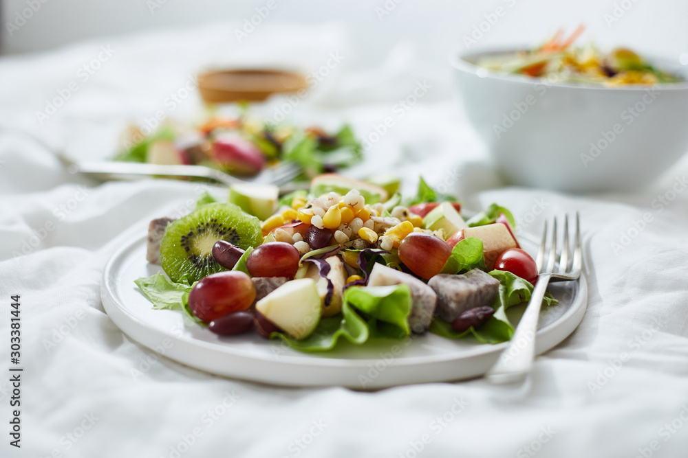 Delicious fruit salad and different fruits on the white table, healthy food concept. Delicious fruit salad and different fruits on the white table, healthy food concept.