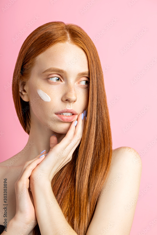 Beautiful young ginger woman with cream on face Beautiful young ginger woman with cream on face