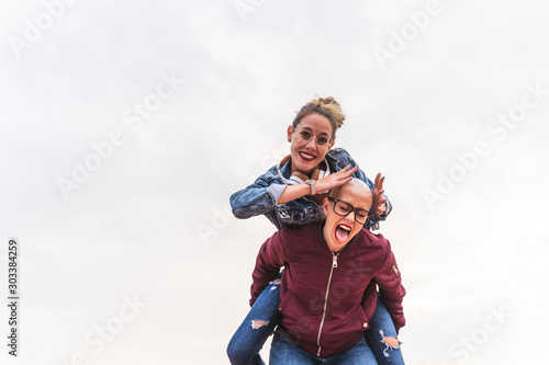Hipster Woman Carrying Her Friend on her Back.