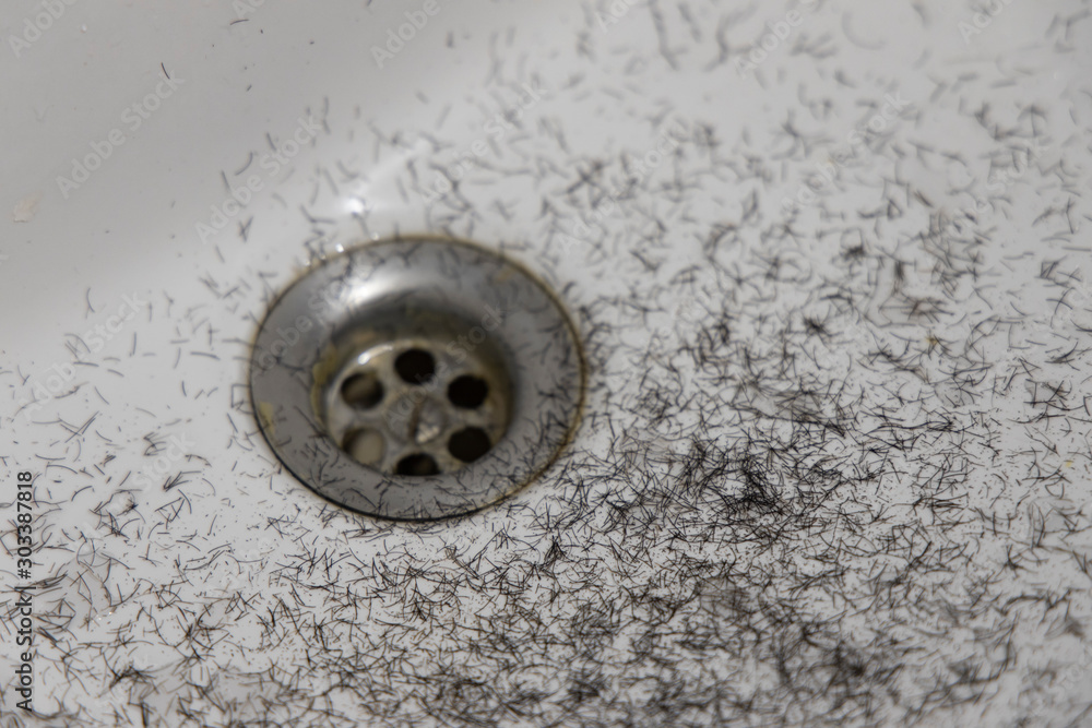 shaved hairs from male face stubble white sink smooth background surface and drain, disgusting organic view shaved hairs from male face stubble white sink smooth background surface and drain, disgusting organic view