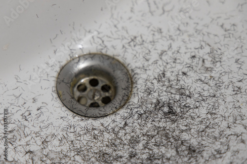 shaved hairs from male face stubble white sink smooth background surface and drain, disgusting organic view 