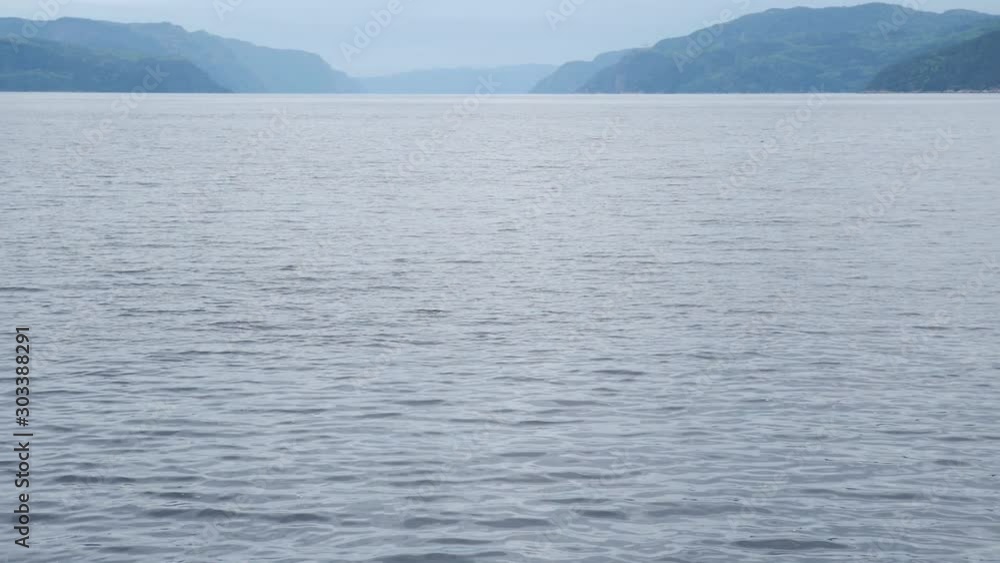 Panning left to reveal large body of water with mountains in the background Panning left to reveal large body of water with mountains in the background