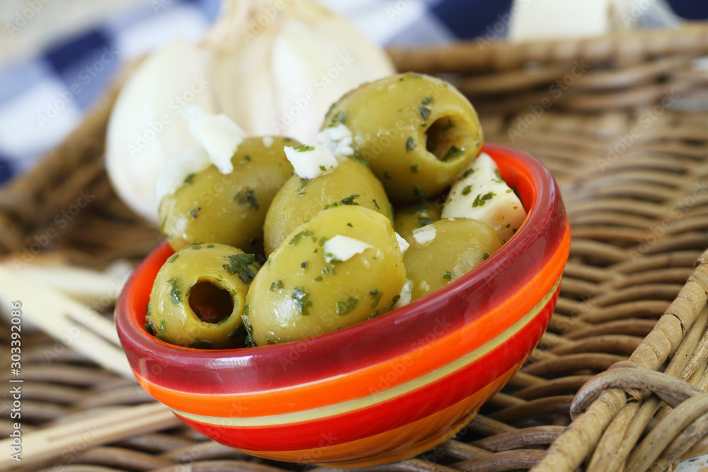 Φωτογραφία Ripe and delicious green olives with fresh garlic in colorful clay bowl, closeup