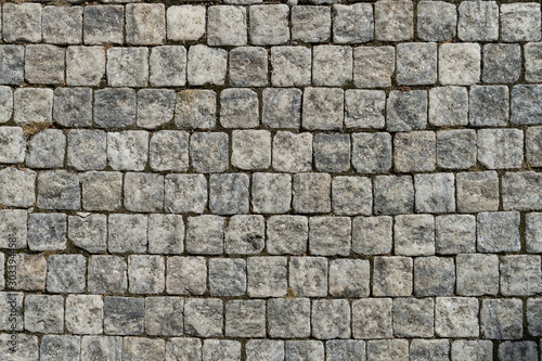 European cobblestone pavement square. Gray stone background, textured pedestrian pavement.