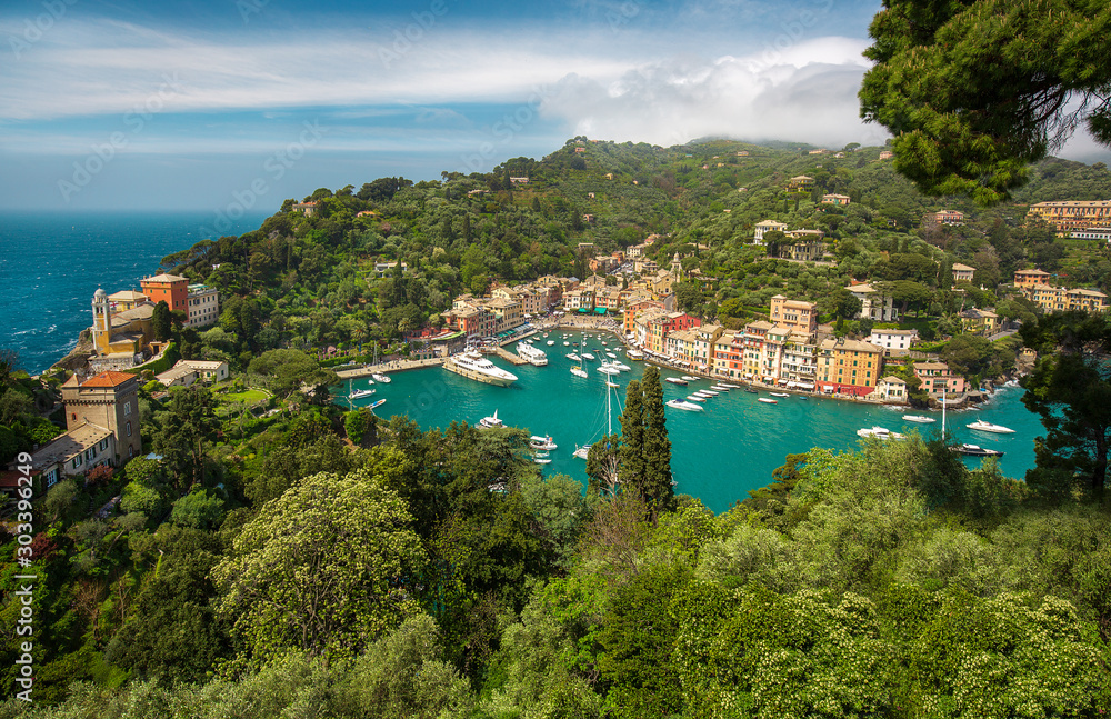 Panorama of Portofino town with multicolored houses and villas, sea and harbor bay with fishing boats and luxury yachts on Italian riviera in Liguria, Italy