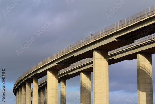 Close-up of a large concrete highway bridge in front of dark clouds in Italy © leopictures