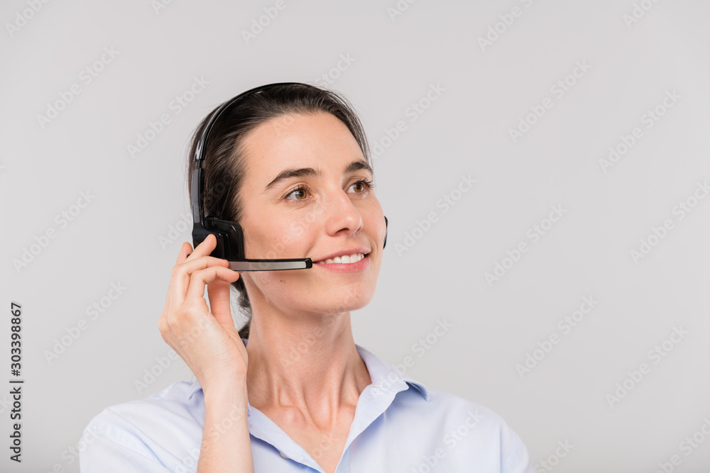 Happy young brunette operator with headset talking to clients online Happy young brunette operator with headset talking to clients online