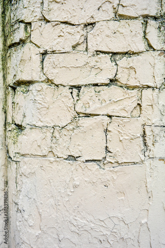 Texture of light yellow paint stucco on brick wall. Imitation of old castle wall