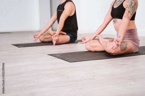 young man and woman practicing yoga sport at the gym. Healthy lifestyle. close up view