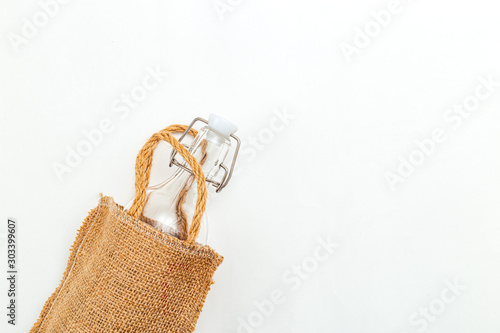 Bag of linen and reusable bottle on white background. Copy space