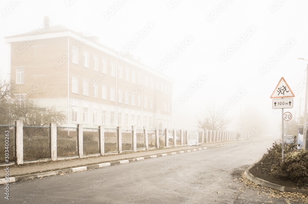 Old city street in fog, autumn weather
