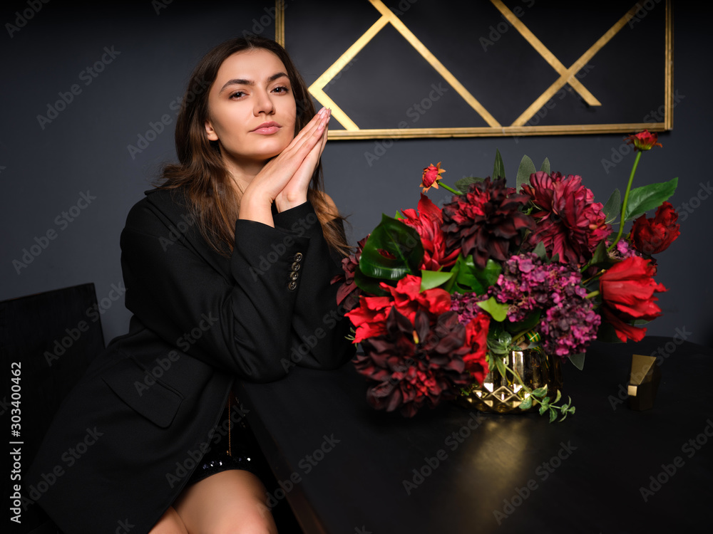 Φωτογραφία Low key photo of cute young lady in mini skirt and jacket, she is sitting behind