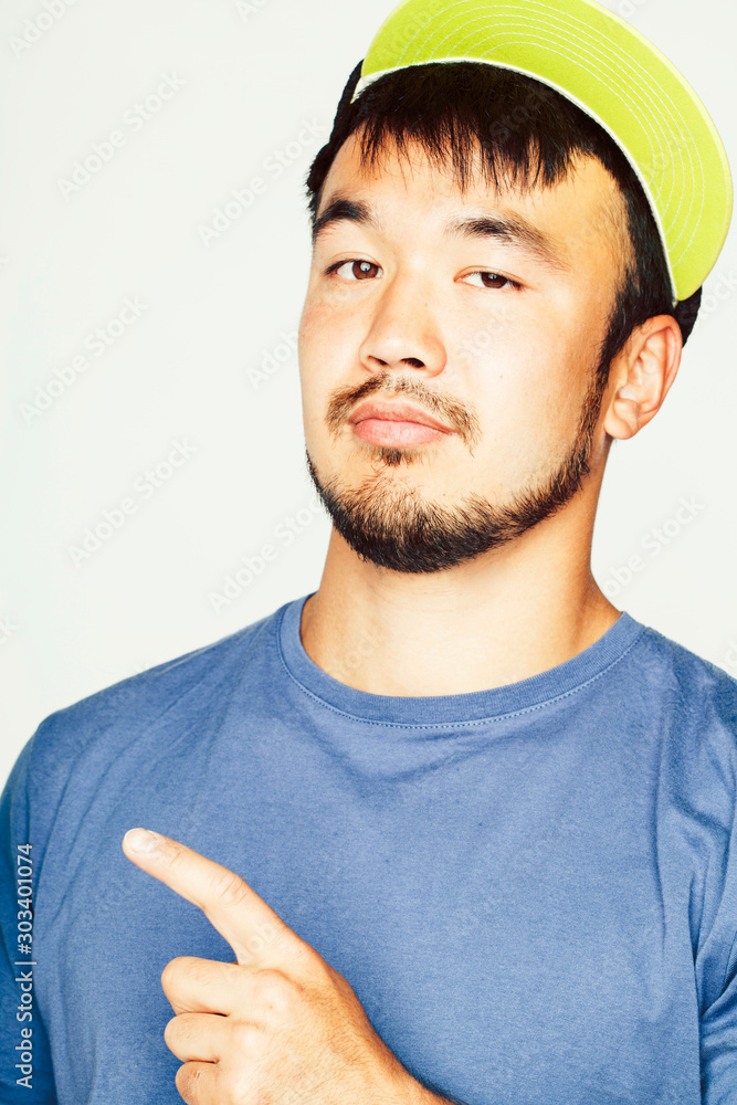 Fototapeta premium young asian man in hat and headphones listening music on white background