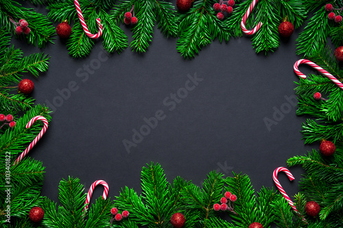 Christmas frame border wirh fir branch  candy cane and baubles on black background