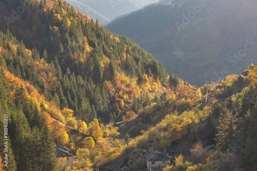 Colorful autumn landscape of the small bulgarian village Varbovo, situated in the hearth of Rhodope Mountain litted up by the sunset. photo