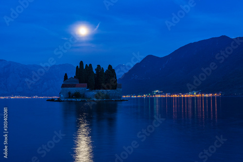 Island of Saint George litted up by the rising Moon. Moon light reflecting at water. Bay of Kotor at blue hour. Cityscape at night, background. © RaDa
