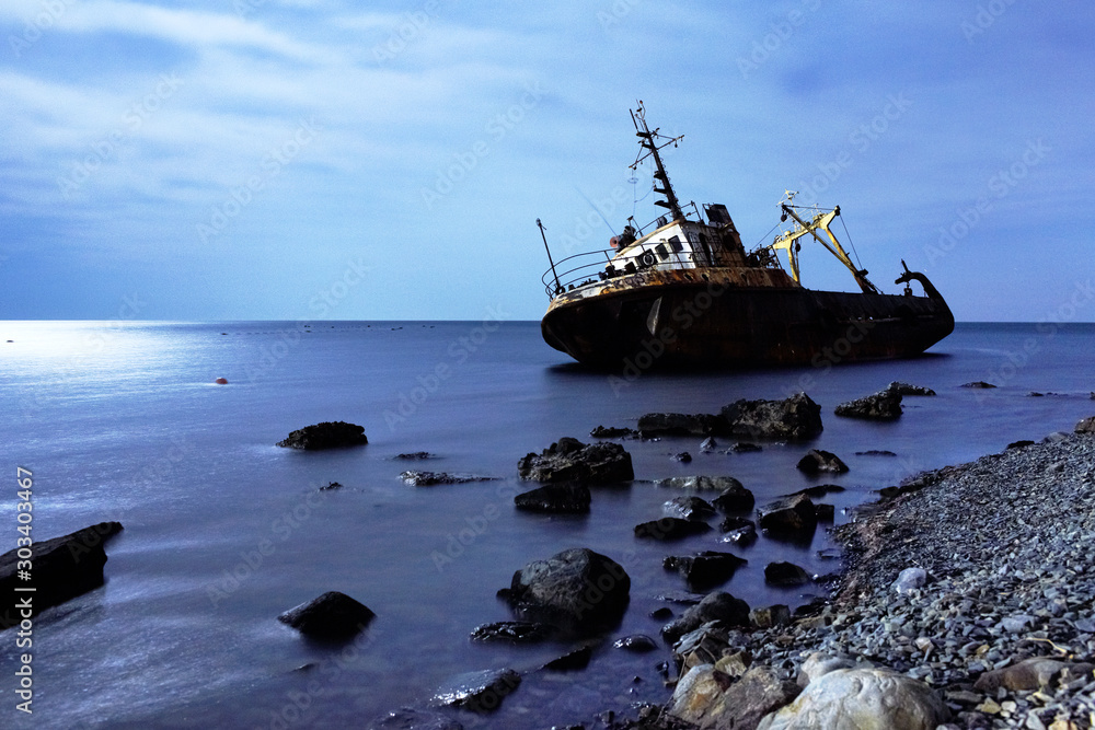 Ship on stones in the sea