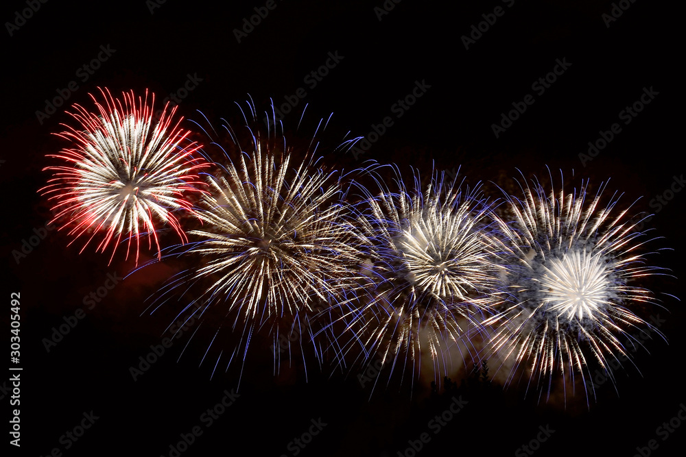 White, blue and red fireworks display on dark sky background