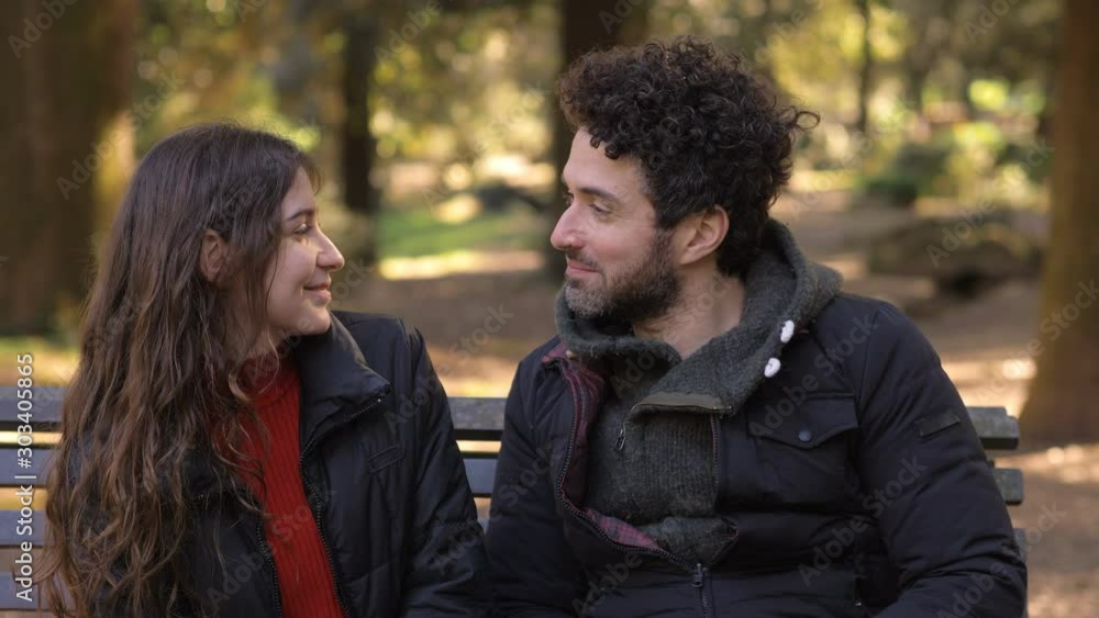Romantic first date.Shy man kissing young woman in the park Romantic first date.Shy man kissing young woman in the park