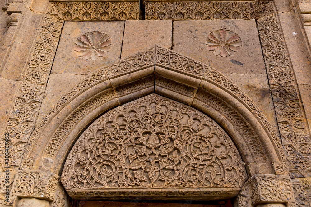 Tufa tympanum with ancient decorative ornament on Armenian monastery in Gosh village