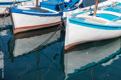 Details of two boats and reflections in a pier in Kamini beach, Hydra Island