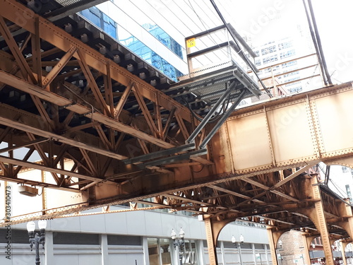 Industry view with iron   steel architecture. Old brown metal structure. Urban design  engineering machinery near high tall business building. Office skyscrapers   stairs  concrete  bridge  factory. 