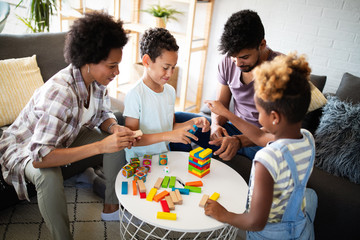Happy family playing jenga together at home.