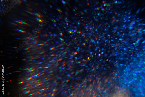 Easy to add lens flare effects for overlay designs or screen blending mode to make high-quality images. Abstract sun burst, digital flare, iridescent glare over black background. Defocused bokeh.