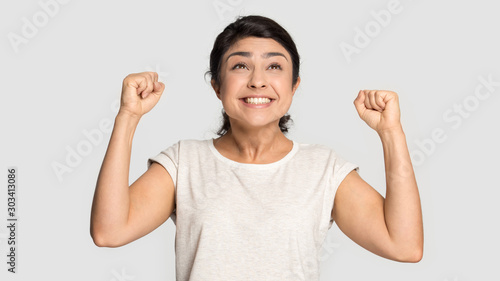 Excited overjoyed Indian woman celebrating win close up