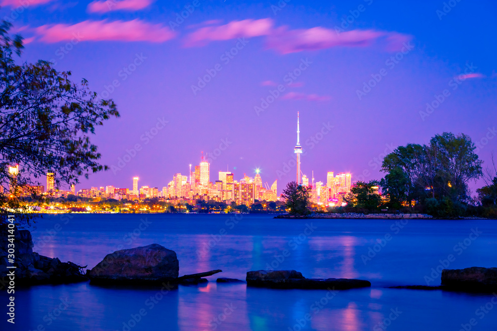View of Toronto skyline and Lake Ontario from Humber Bay Park area during night time. 
