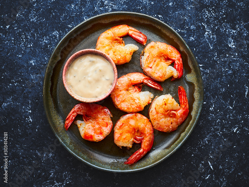 Grilled king prawns with pepper sauce in a plate top view 