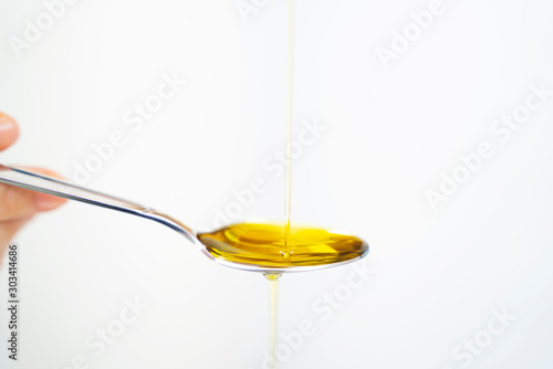 olive oil and spoon isolated on a white background