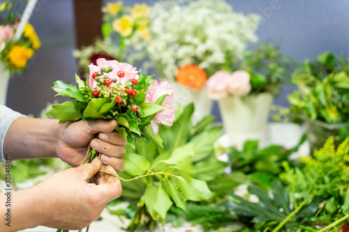 Closeup of a florist making a bunch of flowers in flower shop