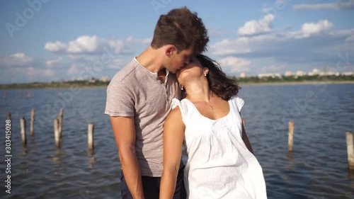 Beautiful couple in love kissing on the beach. Young guy and girl kissing on first date. Honeymoon. A couple on their honeymoon.