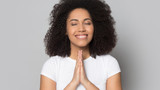 Head shot smiling African American girl folded hands in prayer