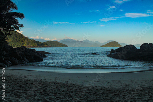 Praia do Portugues, Ubatuba, Sao Paulo, Brazil - Paradise tropical beach with white sand, blue and calm waters, without people on a sunny day and blue sky of the Brazilian coast in high resolution