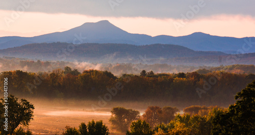 early misty morning after sun rise  with Camel's hump mountain in autumn 
