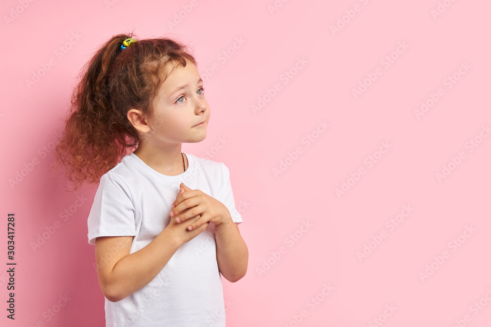 Little caucasian girl in white t-shirt stand looking up, dreaming about new toy isolated over pink background Little caucasian girl in white t-shirt stand looking up, dreaming about new toy isolated over pink background