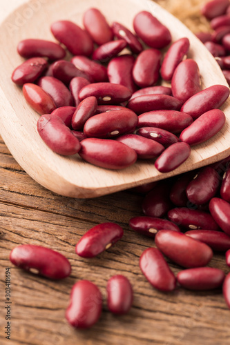 Red kidney bean close up rith spoon on wooden desk photo