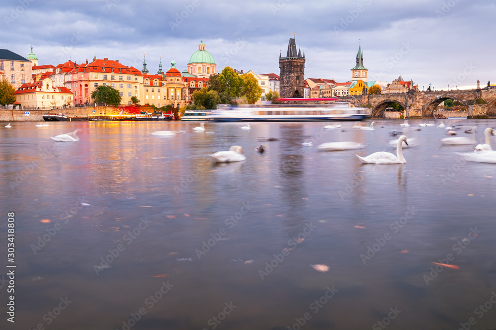 Beautiful view of Old Town buildings and Charles Bridge along the Vltava river at sunset in Prague
