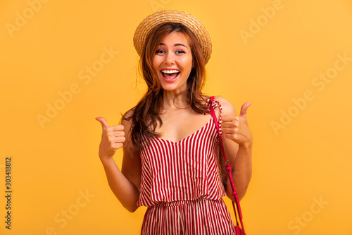 Happy attractive woman holding glass of champagne.Image of cute alluring woman in black elegant dress holding glass of champagne while taking selfie photo isolated over yellow wall. Copy space