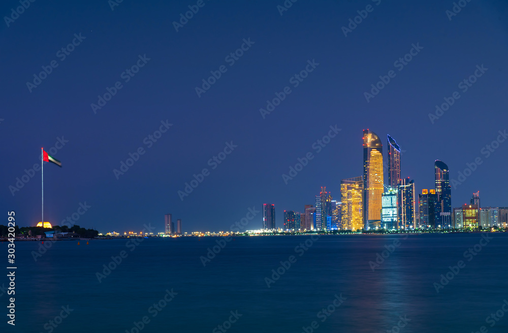 Abu Dhabi downtown night skyline reflected in the seaside